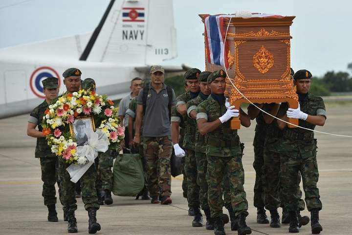 An honour guard carries the coffin of Samarn Kunan, 38, a former member of Thailand’s elite navy SEAL unit who died working to save 12 boys and their soccer coach trapped inside a flooded cave, at an airport in Rayong province, Thailand, July 6, 2018.