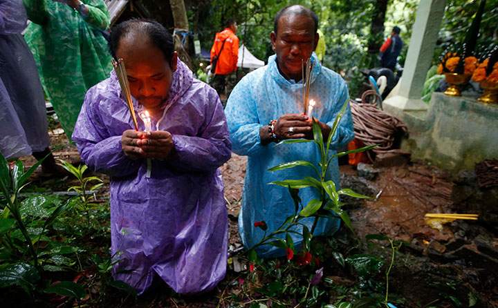 Relatives of 12 young soccer team members and their coach pray for their rescue after going missing in a large cave, Wednesday, June 27, 2018, in Mae Sai, Chiang Rai province, northern Thailand.
