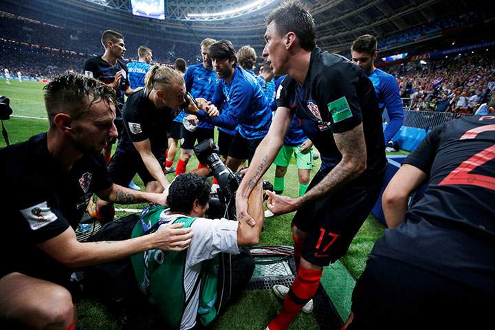Croatia’s Mario Mandzukic helps an AFP photographer Yuri Cortez to his feet after celebrating scoring their second goal.