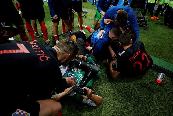 Croatia players celebrate next to an AFP photographer Yuri Cortez after Mario Mandzukic scores their second goal.