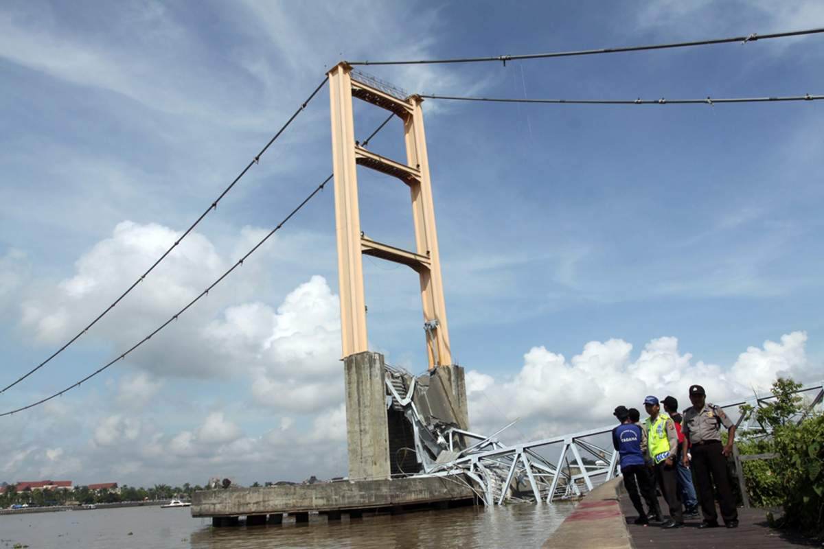 Rescuers inspect the ruin of Kutai Kartanegara bridge in Tenggarong, East Kalimantan, Indonesia, Sunday, Nov. 27, 2011.