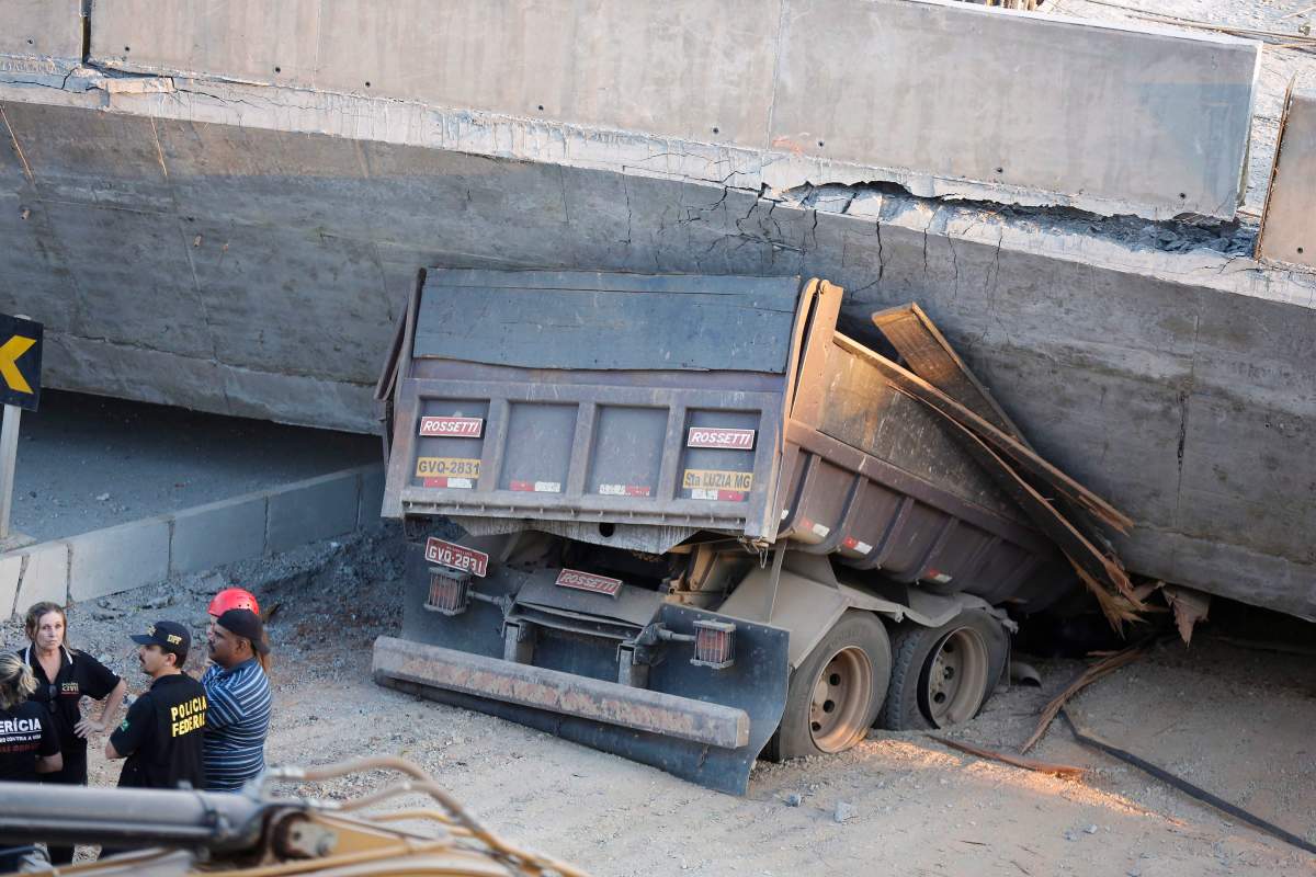 A truck is trapped underneath a collapsed bridge in Belo Horizonte, Brazil, Thursday, July 3, 2014.