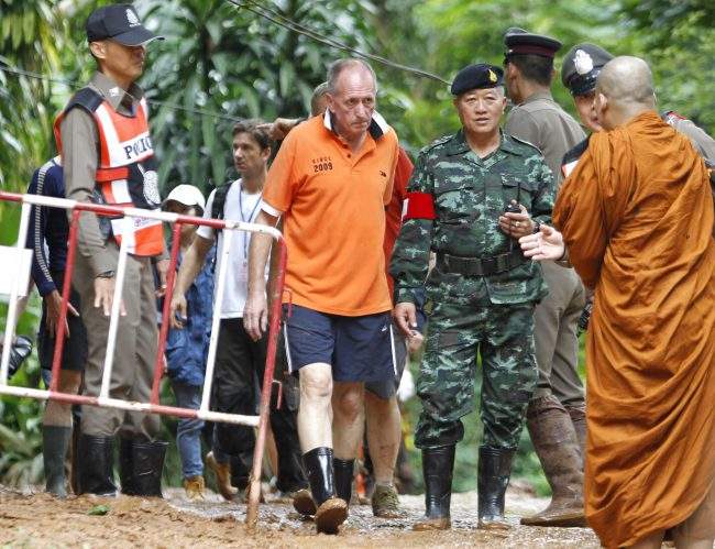 British cave diver Vern Unsworth walks next to a Thai soldier and policemen during the rescue operations for the youth soccer team and their coach, at the Tham Luang cave in Khun Nam Nang Non Forest Park, Chiang Rai province, Thailand, 30 June 2018