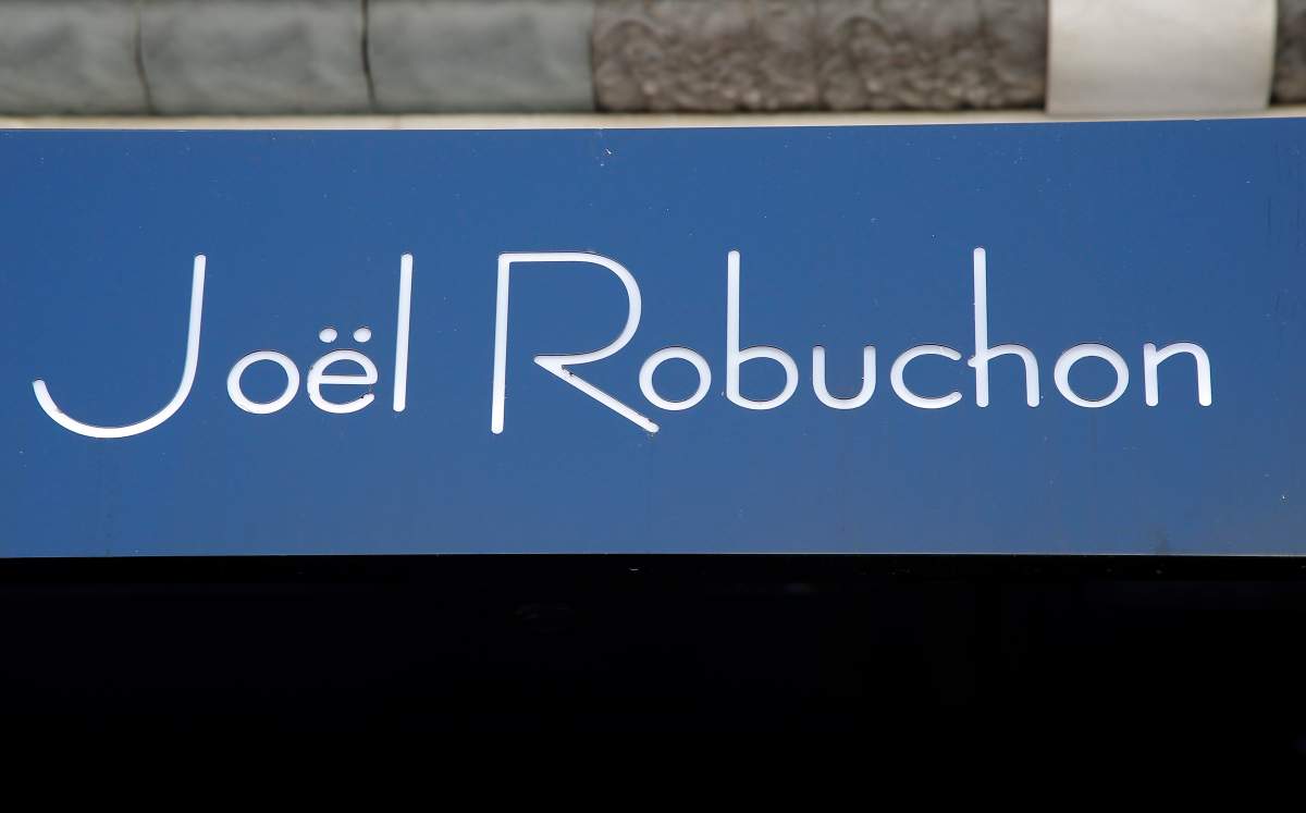 French chef Joel Robuchon’s name is pictured on his restaurant in Paris, Monday, Aug.6, 2018. Robuchon, a master chef who shook up the stuffy world of French haute cuisine by wowing palates with the delights of the simple mashed potato and giving diners a peek at the kitchen, has died. He was 73. (AP Photo/Michel Euler)
