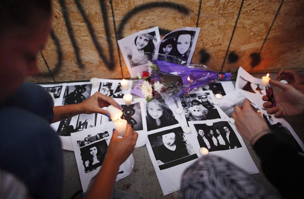 People light candles and leave photos of 18-year-old victim Reese Fallon at a memorial remembering the victims of a shooting on Sunday evening on Danforth Avenue in Toronto on Monday, July 23, 2018.