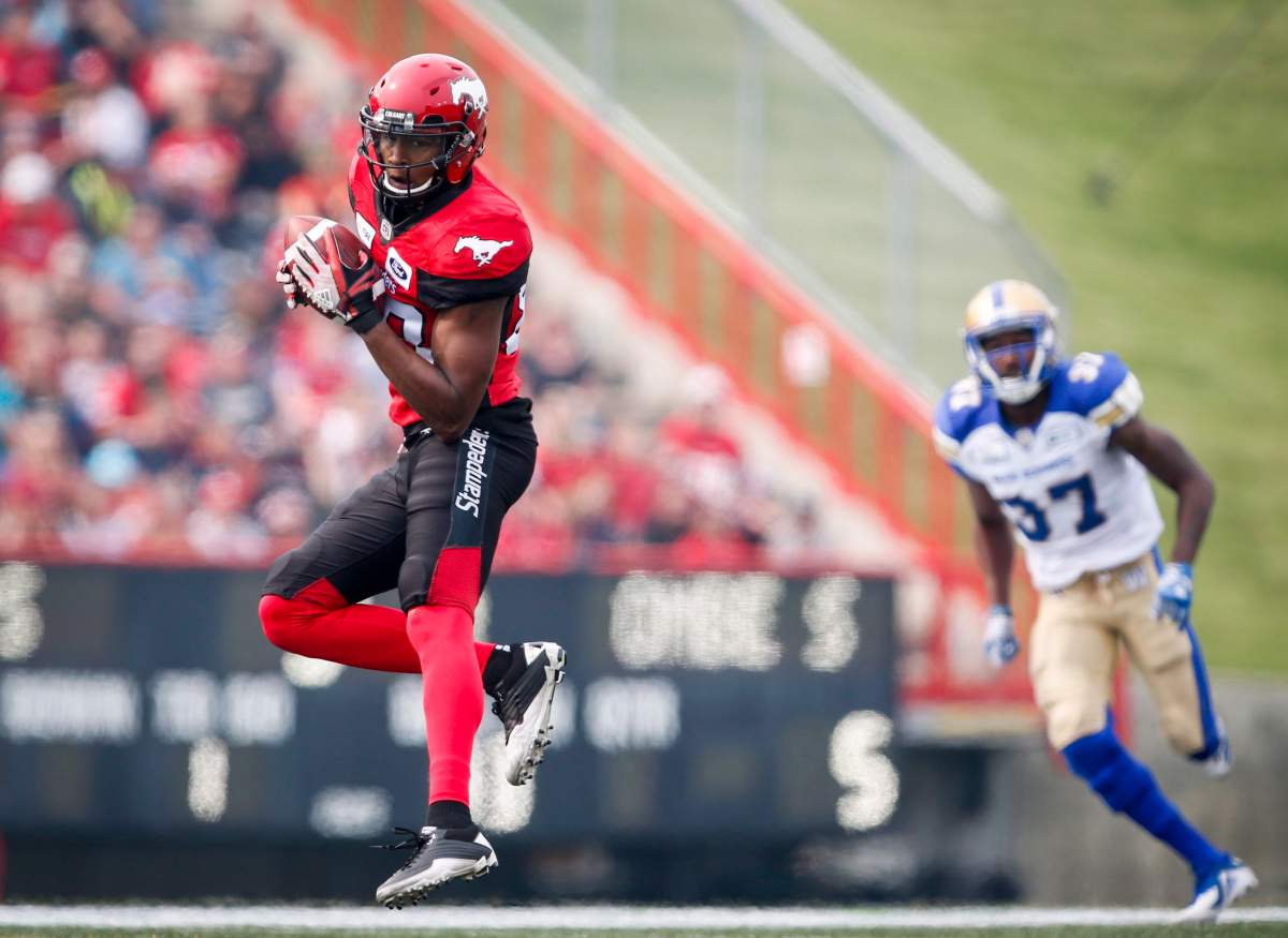 Winnipeg Blue Bombers' Brandon Alexander, right, looks on as Calgary Stampeders' Kamar Jorden catchess a pass during second half CFL football action in Calgary, Saturday, Aug. 25, 2018.