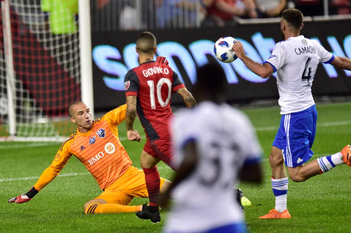Toronto FC forward Sebastian Giovinco chips over Montreal Impact goalkeeper Evan Bush to score as Impact defender Rudy Camacho looks on.during first half MLS soccer action in Toronto on Saturday, Aug. 25, 2018. 