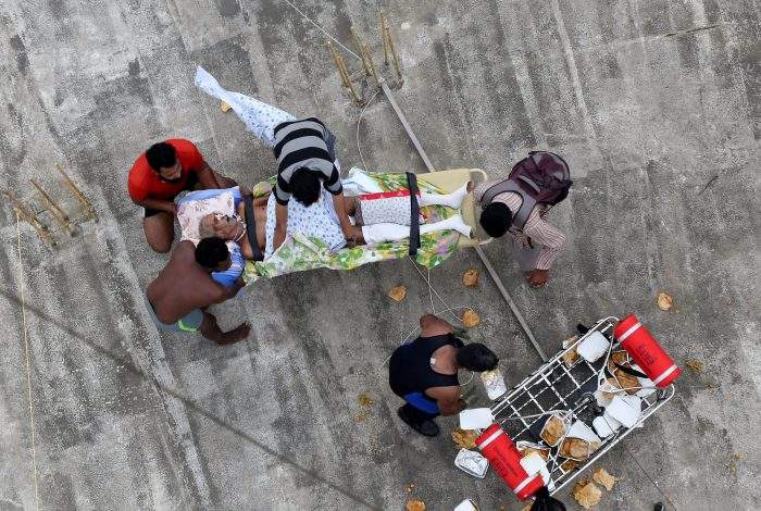 A sick man waits to be airlifted by the Indian Navy soldiers from a flooded area in the southern state of Kerala, India, August 17, 2018.