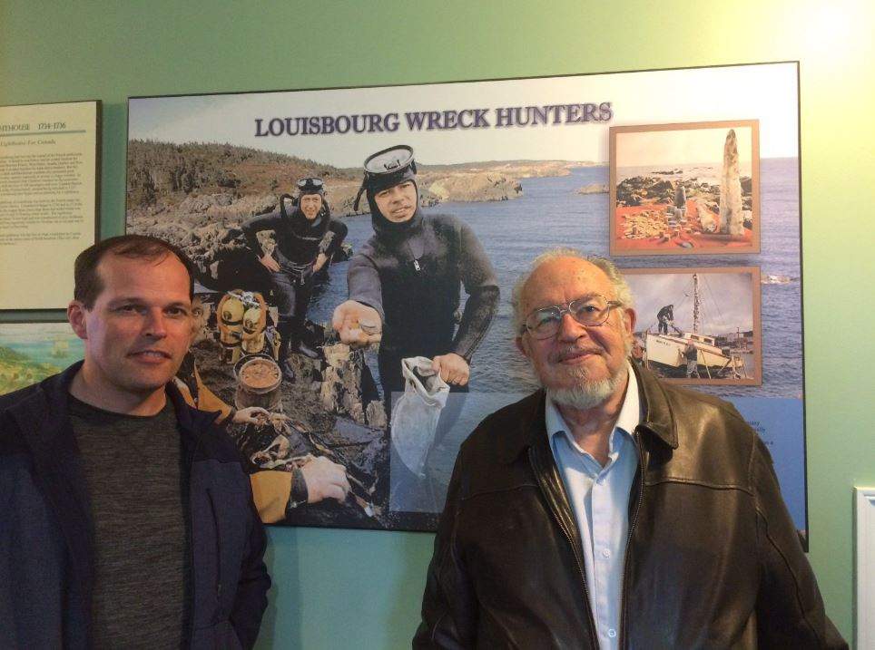 Alex Storm, right, poses with his son Jason Storm in front of a display about him and his treasure hunting days in this undated handout photo. 