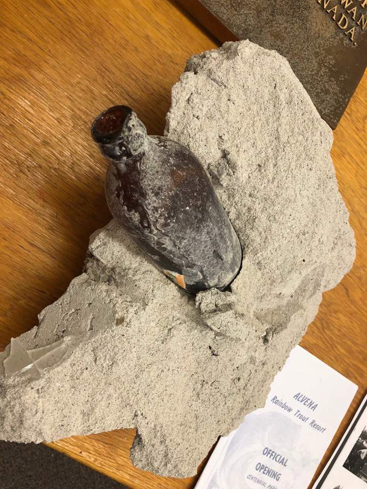 A beer bottle is shown embedded in concrete in this handout image.