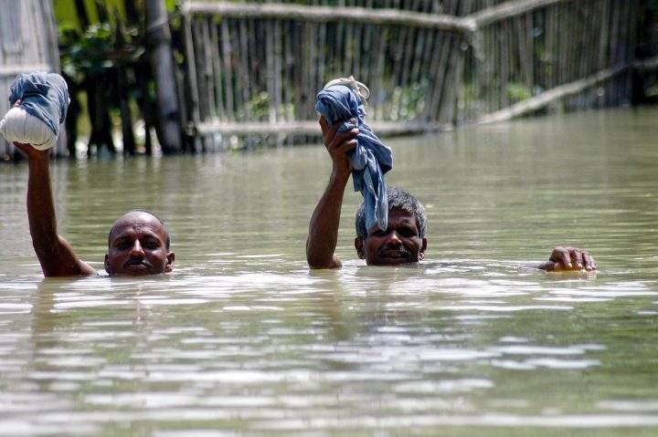 Two men wade through flood waters in Madhepura district in Bihar, India, Monday, Sept. 1, 2008.