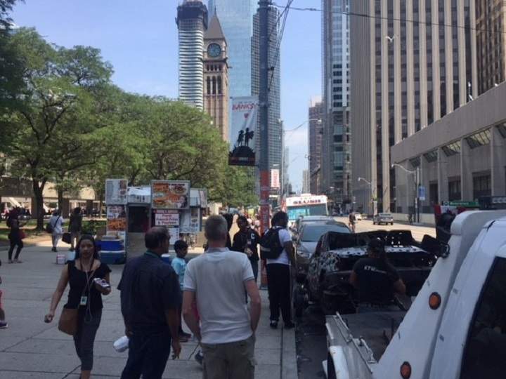 “Shot Up Car” by Viktor Mitic makes its way to Nathan Phillips Square with the aid of a tow truck.