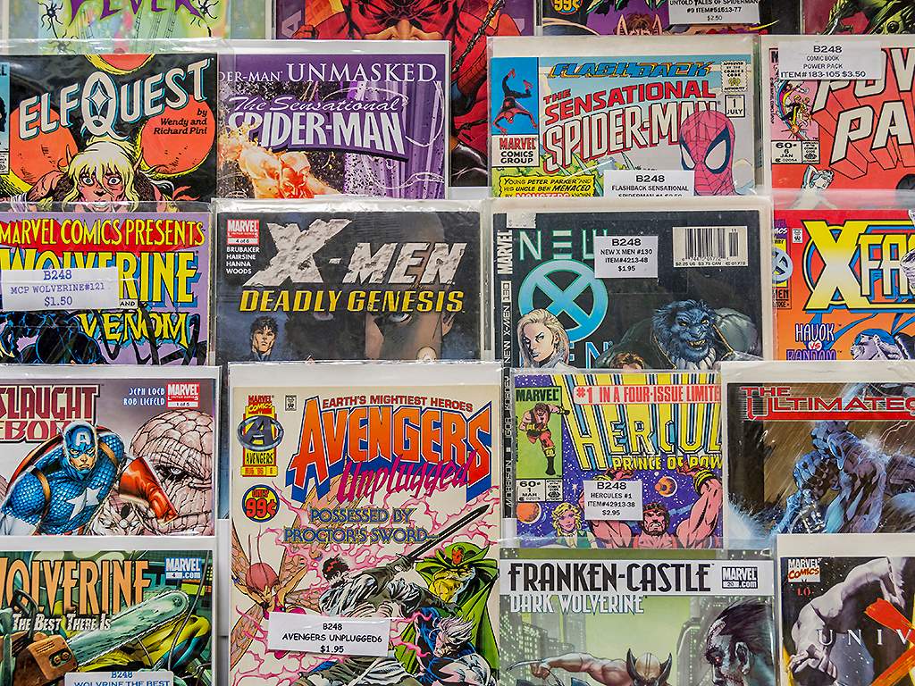 A rack of comic books for sale at a flea market.