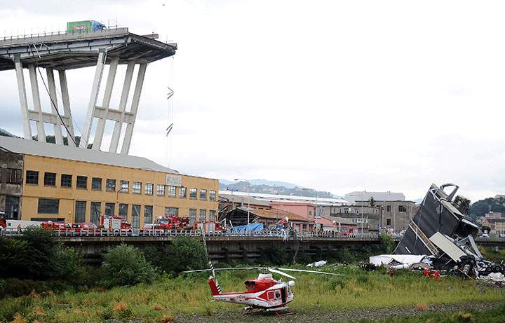 Rescue workers are seen at the collapsed Morandi Bridge in the Italian port city of Genoa, August 14, 2018.