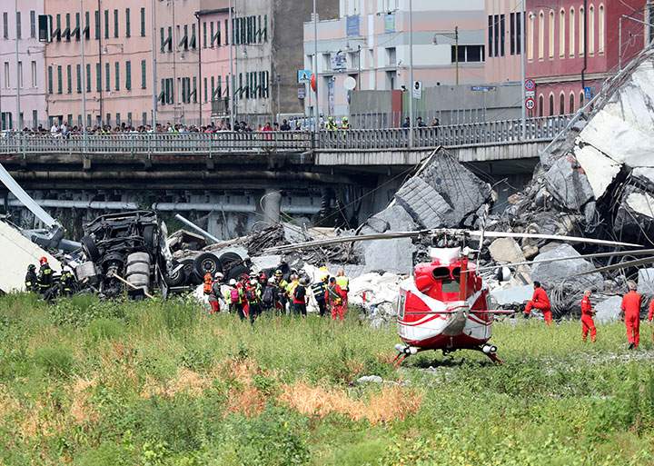 Rescue workers are seen at the collapsed Morandi Bridge in the Italian port city of Genoa, August 14, 2018.