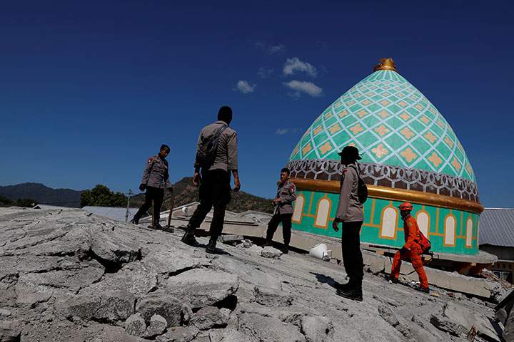 Rescuers and policemen walk on top of a collapsed mosque as they try to find survivors after an earthquake hit on Sunday in Pemenang, Lombok Island, Indonesia, August 7, 2018.