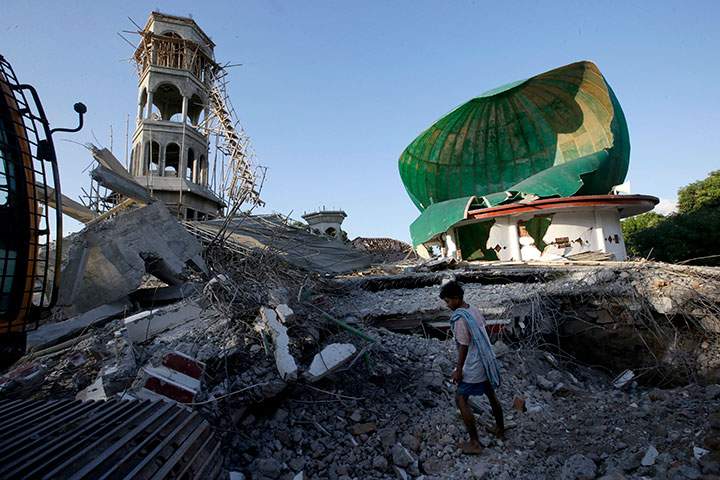 A resident inspects a mosque damaged by an earthquake in North Lombok, Indonesia, Tuesday, Aug. 7, 2018.