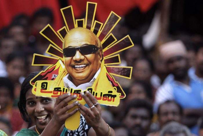 In this April 22, 2014 file photo, a supporter holds up a cutout with a portrait of Muthuvel Karunanidhi during an election rally in Chennai, India.