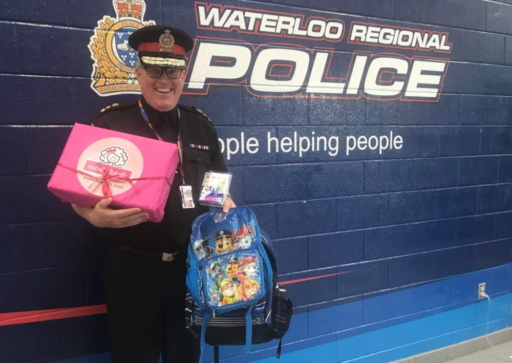 Waterloo police Chief Bryan Larkin with a couple of the more-than-1,400 backpacks that were donated.