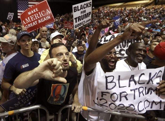 In this Tuesday, July 31, 2018, file photo, supporters of U.S. President Donald Trump shout down a CNN news crew before a rally in Tampa, Fla.