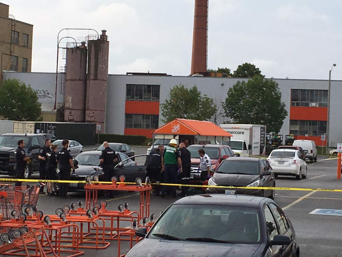 Paramedics tend to a woman who was shot in the parking lot of The Home Depot in Peterborough on Wednesday.