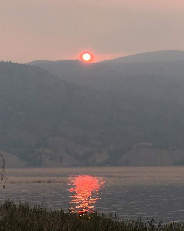 A smoke-filled sunrise over Skaha Lake.