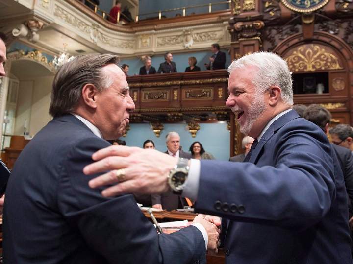 In this 2015 file photo, François Legault, left, and Quebec Premier Philippe Couillard shake hands and exchange holiday greetings as the fall session comes to an end. Insults flew between the political rivals on Day 18 of the Quebec election campaign. Sunday, Sept. 9, 2018.