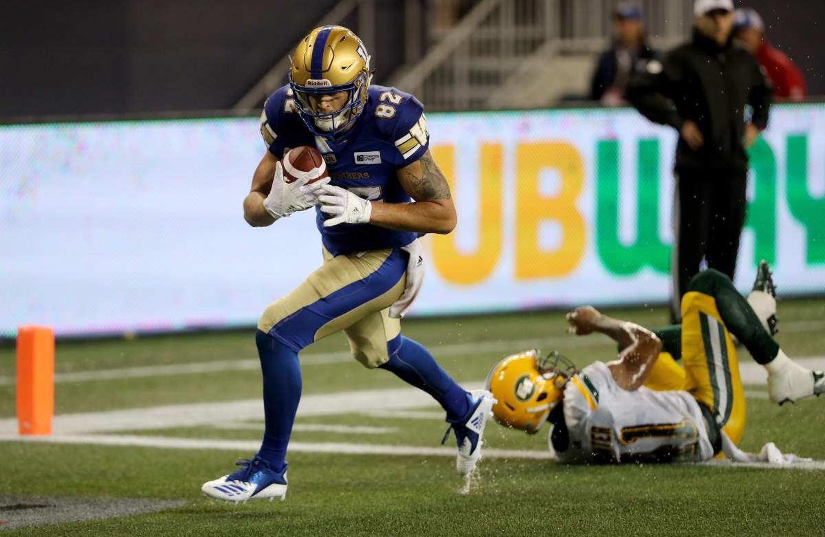 Winnipeg Blue Bombers' Drew Wolitarsky (82) breaks a tackle by Edmonton Eskimos' Hunter Monshadrik (41) to score a touchdown during third quarter CFL action against the Winnipeg Blue Bombers' in Winnipeg on Thursday, June 14, 2018.  (CFL PHOTO - Trevor Hagan).