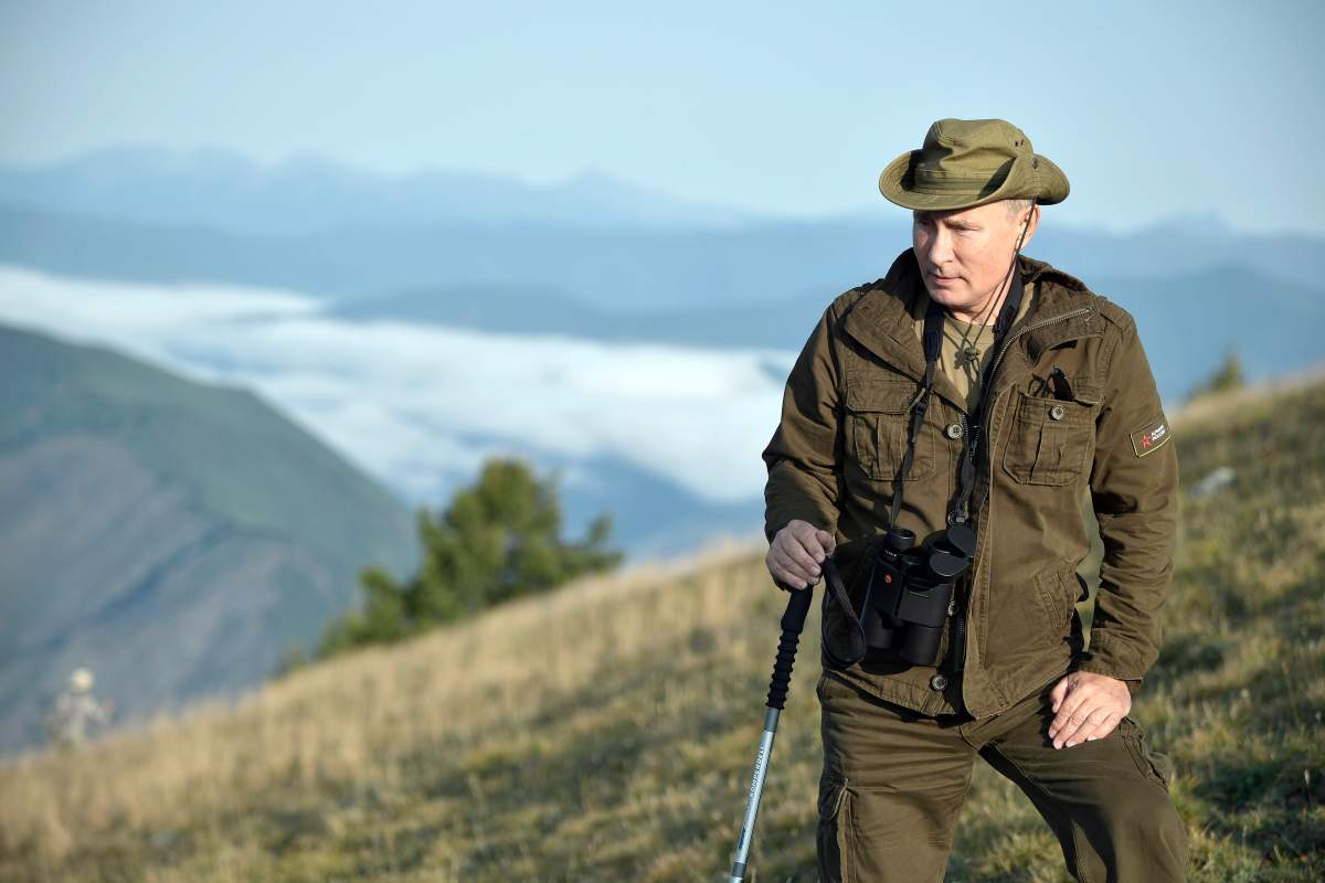 In this Sunday, Aug. 26, 2018, file photo, Russian President Vladimir Putin rests during a mini-break in the Siberian Tyva region, Russia. A Russian state-owned television channel has a new weekly current affairs program devoted to the Russian president. Rossiya 1 aired the first episode of “Moscow. Kremlin. Putin.” on Sunday, Sept. 2. It stressed Putin’s work to address various crises and to stay in touch with ordinary Russians.