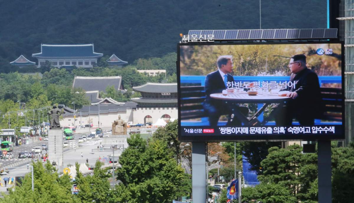 A TV screen shows a photo of South Korean President Moon Jae-in and North Korean leader Kim Jong UN, right, to advertise upcoming Seoul Defense Dialogue in Seoul, South Korea, Wednesday, Sept. 5, 2018. 