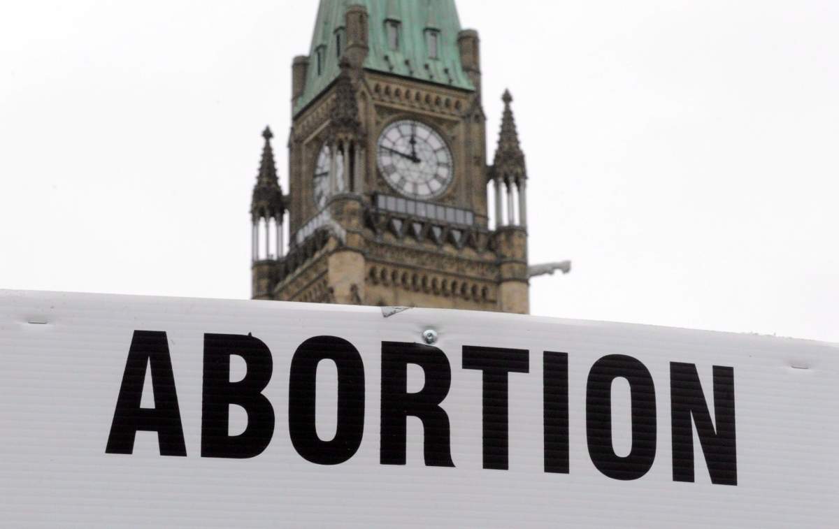 Pro-life supporters hold anti-abortion signs as they take part in the March For Life rally on Parliament Hill in Ottawa on Thursday, May 10, 2012. 