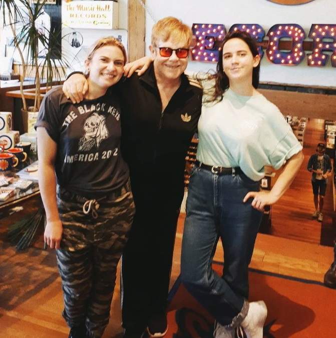 Elton John poses with Sonic Boom record store employees Lauren Mayer, left, and Ali Haberstroh in Toronto in this photo from Sonic Boom's twitter page. 