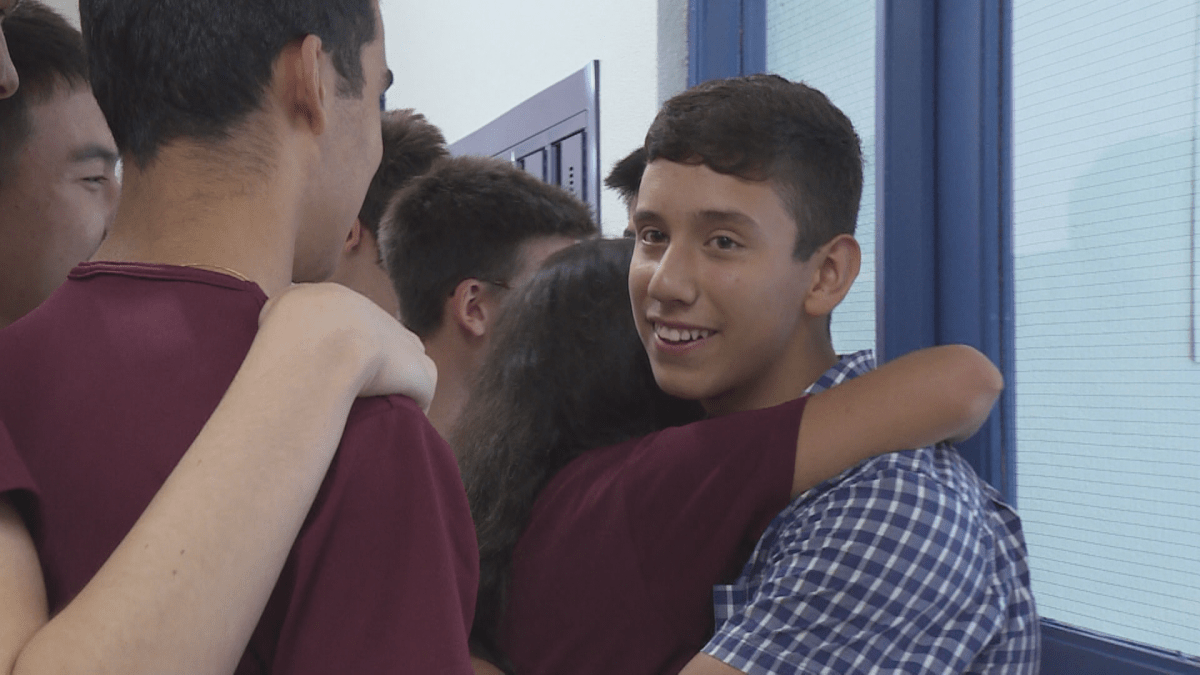 Alois Orozco is hugged by students at Royal West Academy.