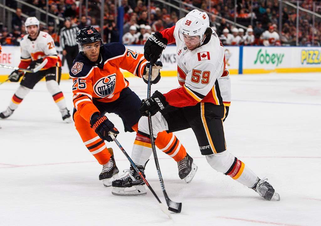 Calgary Flames ' Dillon Dube and Edmonton Oilers' Darnell Nurse battle for the puck during first period NHL preseason action in Edmonton, on Saturday September 29, 2018.
