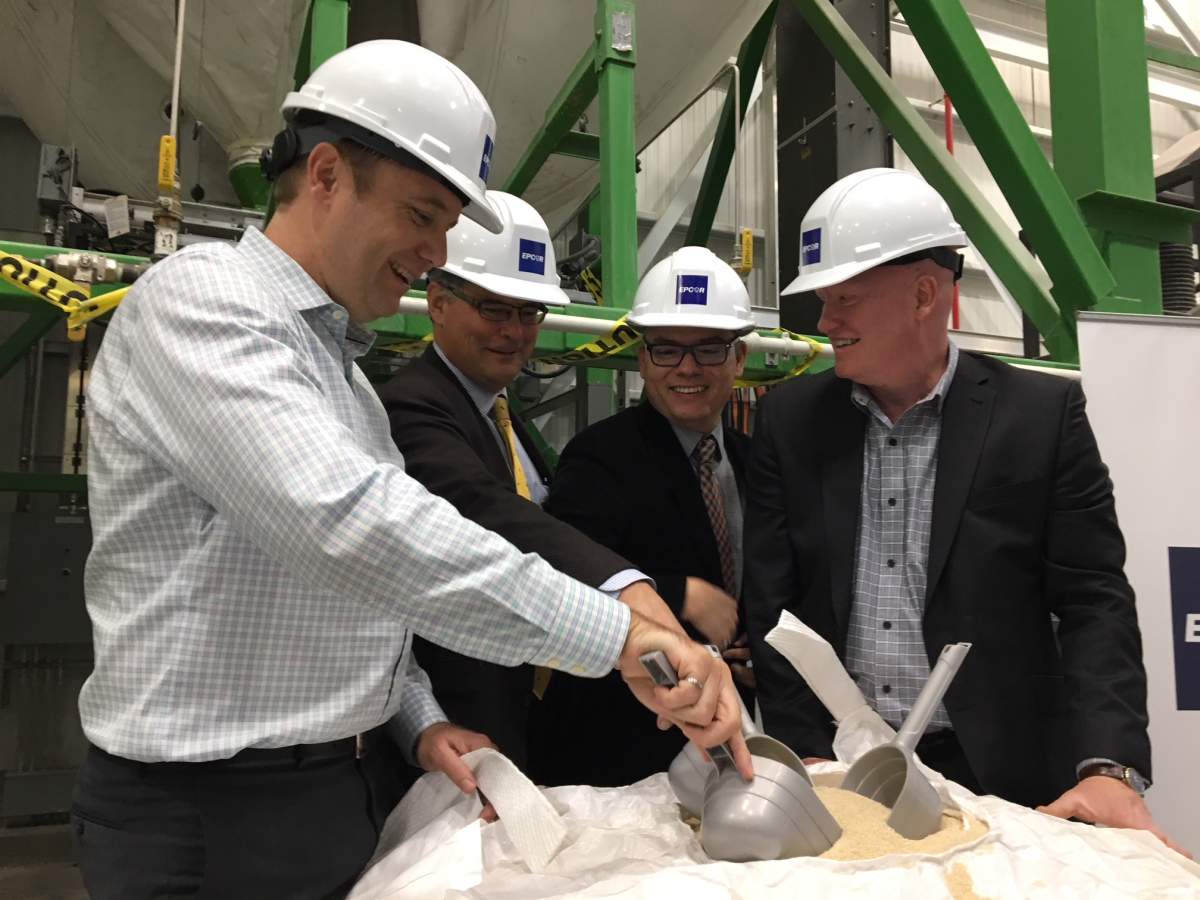 Business and government representatives dig into a bag of fertilizer to celebrate the opening of EPCOR’s new facility