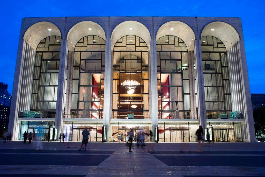 FILE – In this Aug. 1, 2014, file photo, pedestrians make their way in front of the Metropolitan Opera house at New York’s Lincoln Center. The Metropolitan Opera will start regular Sunday afternoon performances for the first time in its century-plus history during the 2019-20 season. (AP Poto/John Minchillo, File)