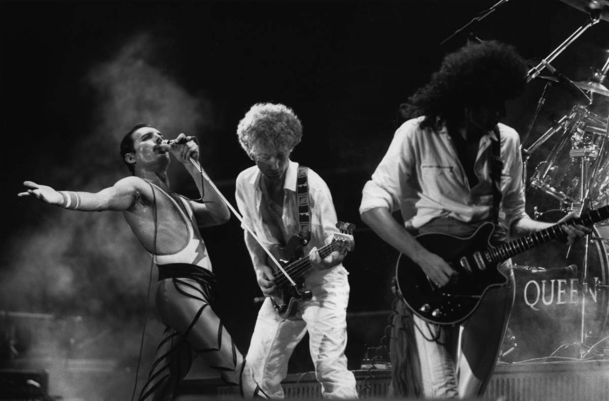 British rock group Queen in concert, from left to right; Freddie Mercury, John Deacon, and Brian May.