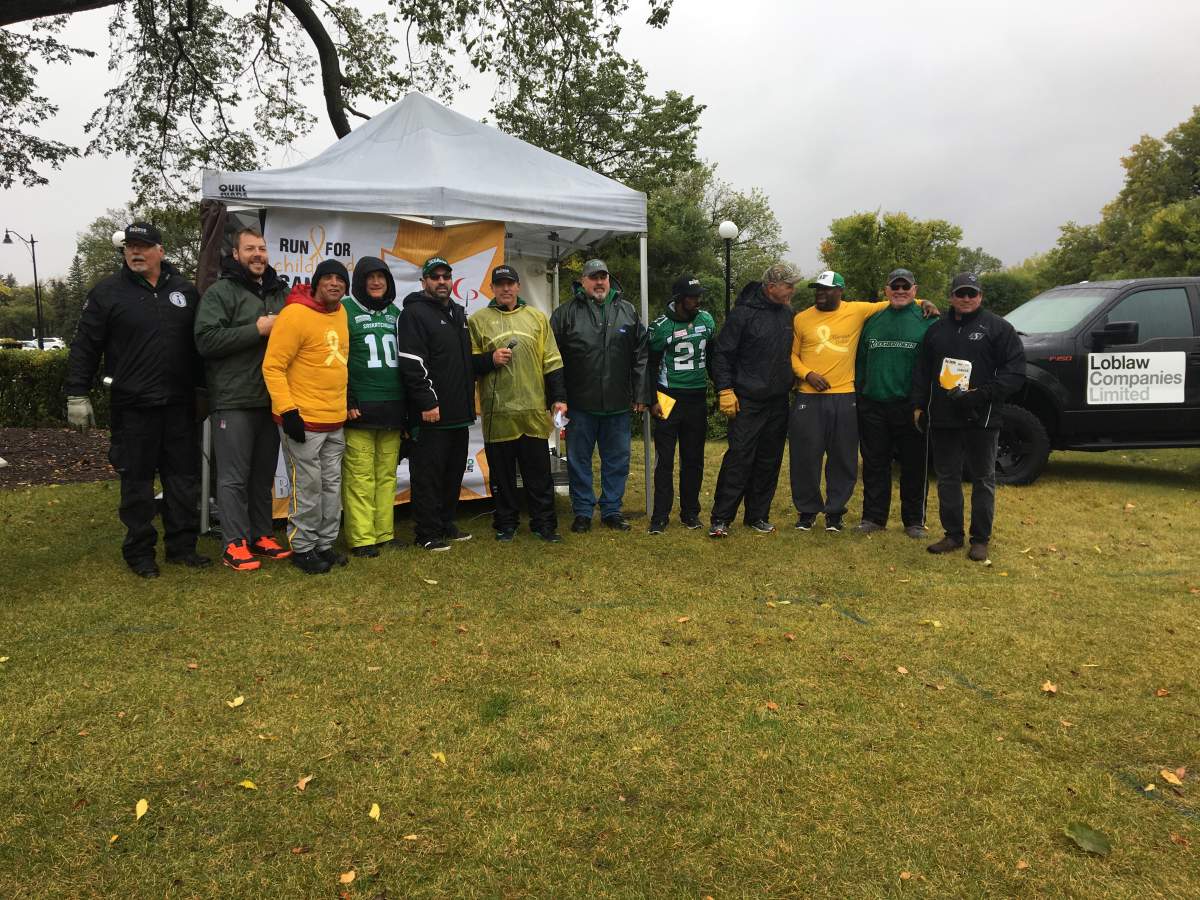 Roughriders alumni braved the rain to raise money for kids battling cancer.