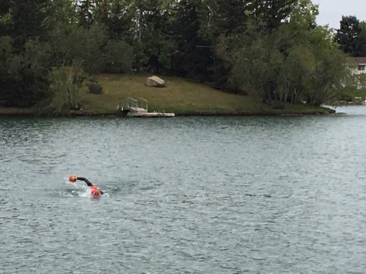 Calvin Zaryski and Myron Tetreault swim in Lake Bonavista in Calgary. Sept. 12, 2018.