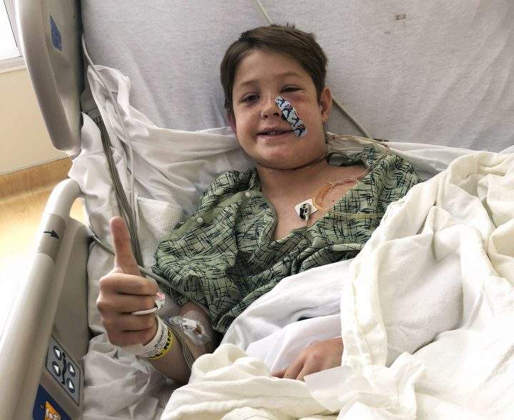 In this Monday, Sept. 10, 2018 photo Xavier Cunningham, of Harrisonville, Mo., gives a thumbs up while recovering at the University of Kansas Hospital in Kansas City, Kan., after surgery to remove a meat skewer that penetrated his skull from his face to the back of his head.