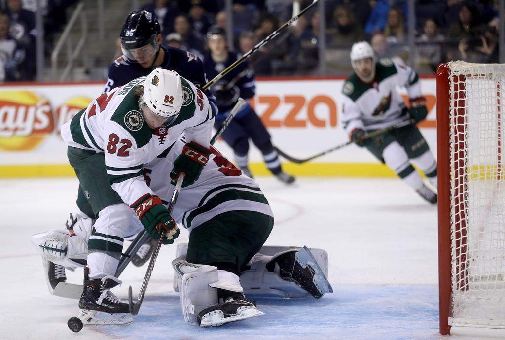 Winnipeg Jets' Marko Dano (56) and Minnesota Wild Justin Kloos (82) battle in front of goaltender Andrew Hammond (35) during second period NHL hockey action during preseason hockey in Winnipeg, Monday, September 17, 2018.