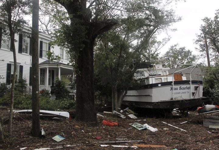 A 40-foot yacht lies in the yard of a storm-damaged home on East Front Street in New Bern, N.C., Saturday, Sept. 15, 2018.