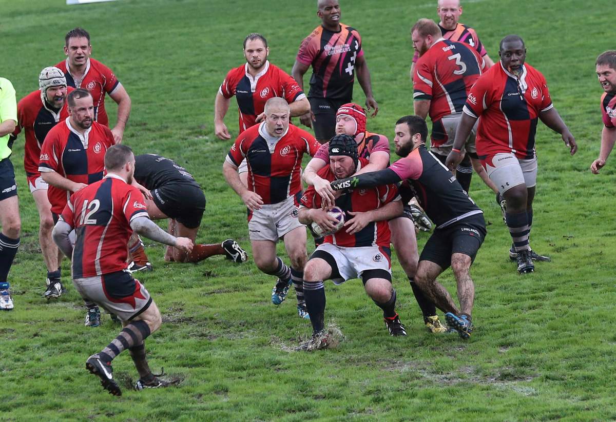 Boston Ironside rugby team player, center, is tackled by Amsterdam lowlanders players during the Bingham Cup gay rugby tournament in Sydney, Australia, Friday, Aug. 29, 2014. 