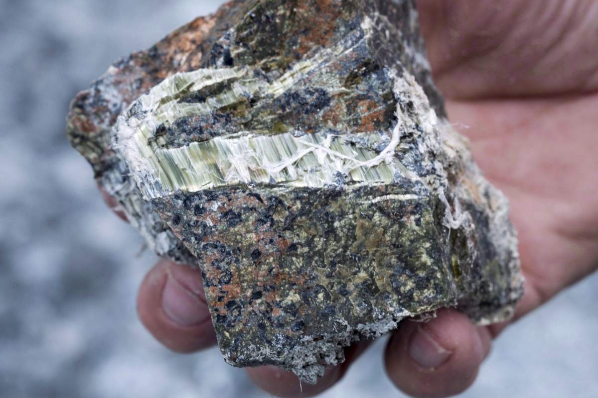 Francesco Spertini holds a chunk of chrysotile asbestos with his bare hands at the now closed Jeffrey mine in Asbestos, Que., in an August 10, 2016, file photo. The federal government is banning the use of asbestos in products. 