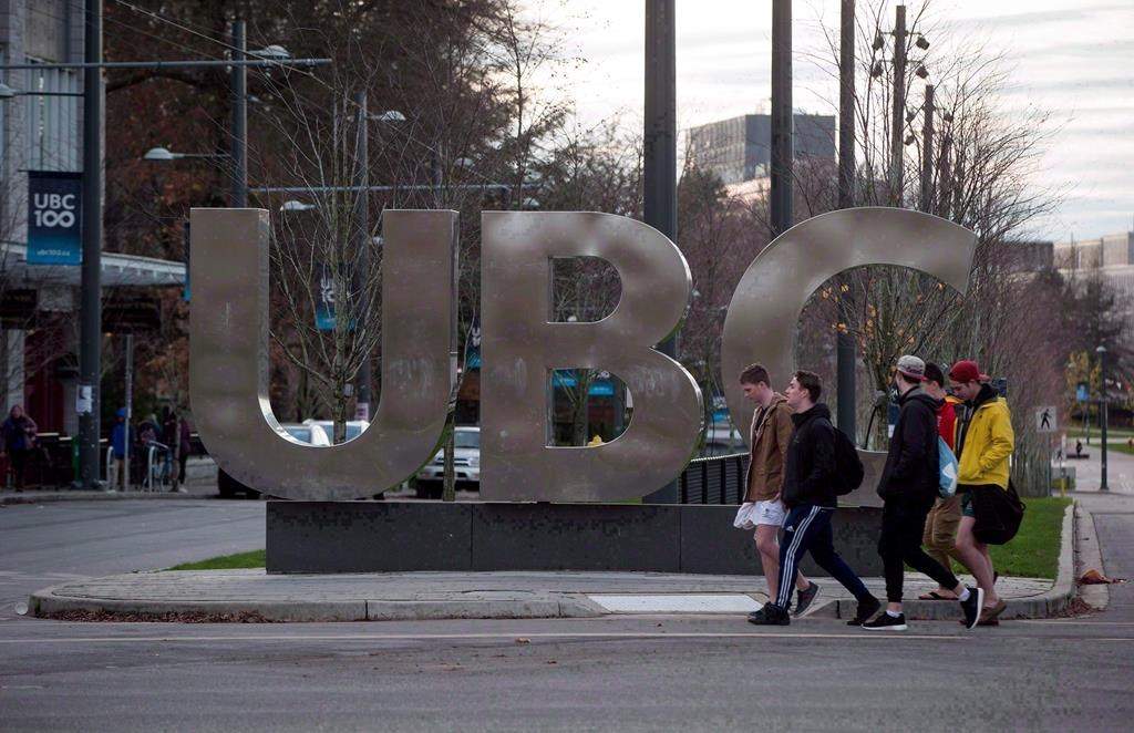 People walk past large letters spelling out UBC at the University of British Columbia in Vancouver, B.C., on Nov. 22, 2015.