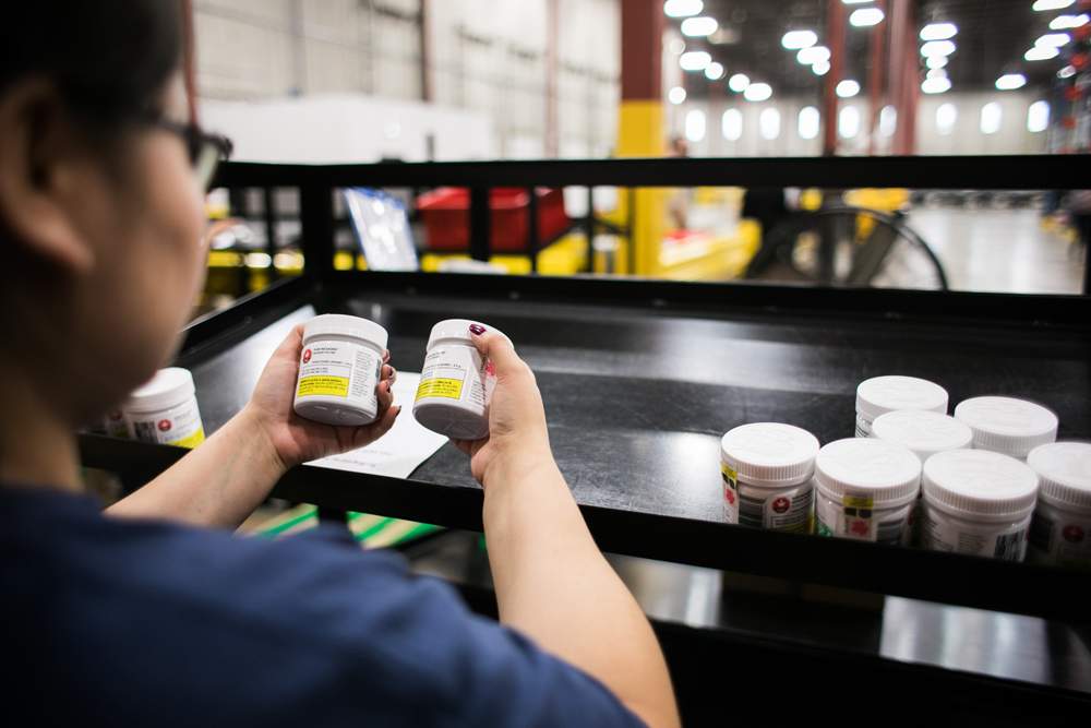 A worker sorts jars of cannabis at the Ontario Cannabis Stores' warehouse in this handout image. 