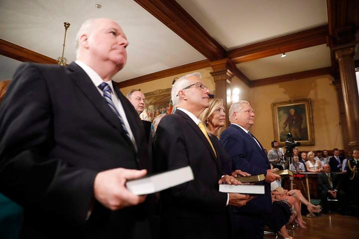 Doug Ford (right) is sworn in as premier of Ontario during a ceremony at Queen’s Park in Toronto on Friday, June 29, 2018. Cabinet ministers Jim Wilson (left to right), Vic Fedeli and Christine Elliott look on.