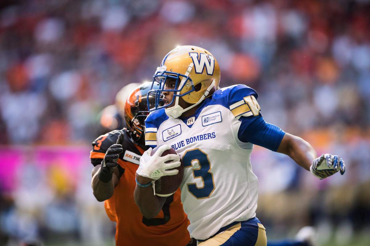 Winnipeg Blue Bombers' Kevin Fogg, front, runs the ball past B.C. Lions' Ricky Collins Jr. after making an interception in the end zone during the first half of a CFL football game in Vancouver on Saturday July 14, 2018. 