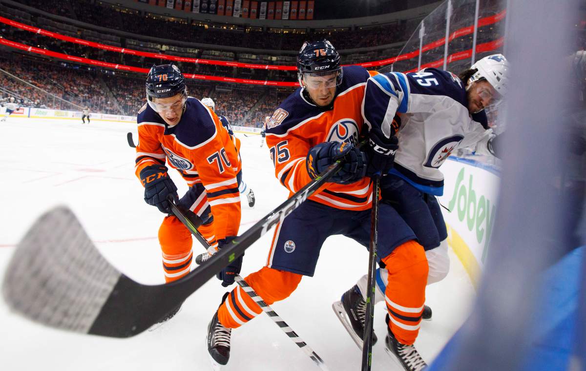 Winnipeg Jets’ Dennis Everberg (45) is checked by Edmonton Oilers’ Evan Bouchard (75) during first period pre-season action in Edmonton, Alta., on Thursday September 20, 2018.