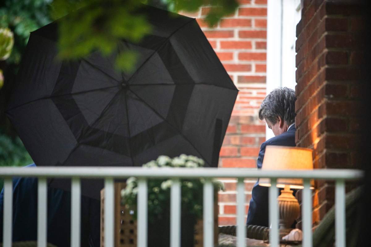 Supreme Court nominee Brett Kavanaugh (R) leaves his home as a member of his security team opens an umbrella to block the view in Bethesda, Md., USA, 25 September 2018.